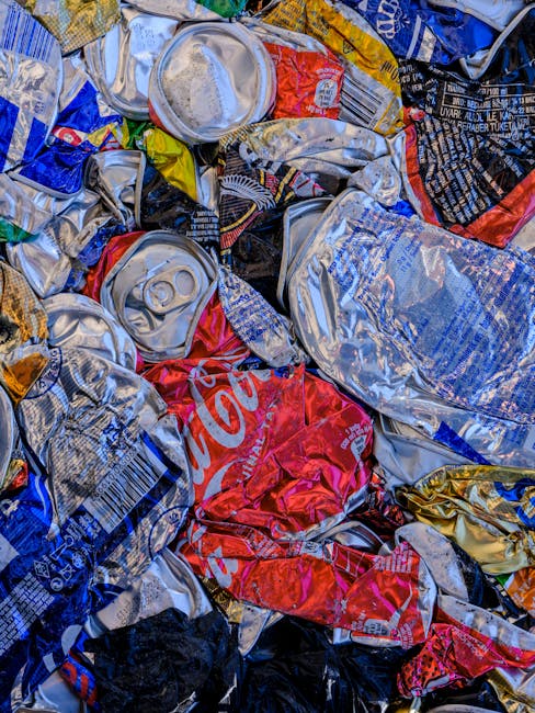 A person's arm and hand are visible, holding a green plastic rubbish bag tightly by its twisted knot at the top. The bag appears to be filled with waste, causing it to bulge and take on a rounded shape. The plastic is semi-transparent, allowing some of the contents to be faintly seen inside, and the surface has a slightly crinkled texture reflecting light. The background is a plain, neutral-toned wall, providing no additional environmental context. The scene is lit with soft, diffuse lighting that highlights the subtle creases and contours of the bag, emphasizing its volume and the act of rubbish collection. The image focuses on an individual’s effort in waste disposal, illustrating private rubbish handling, which may relate to independent waste collection or onsite clearance services provided by waste management companies like Waste Collection Docklands. This simple, clear depiction emphasizes the physical aspect of rubbish removal through flexible, environmentally conscious waste disposal practices.